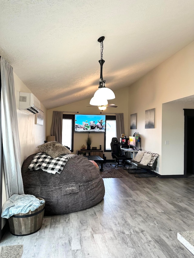 living room with a wall mounted AC, a textured ceiling, hardwood / wood-style flooring, and lofted ceiling