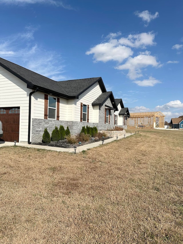 view of property exterior featuring a yard and a garage