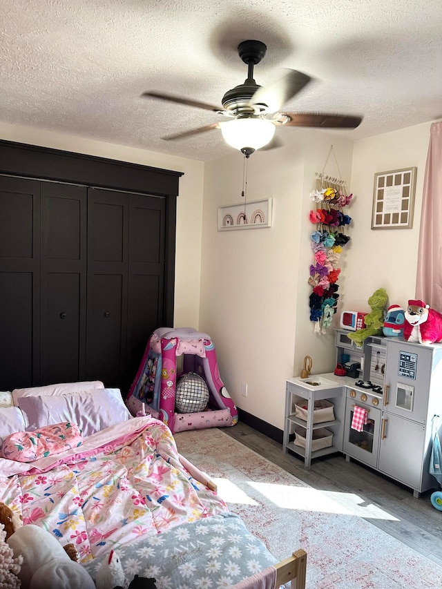 bedroom with a textured ceiling, hardwood / wood-style flooring, and ceiling fan