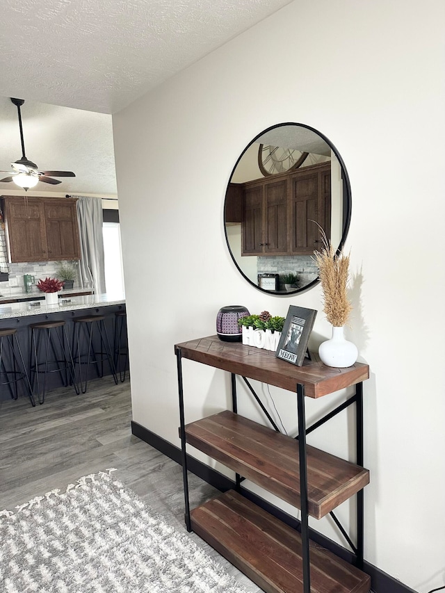 hallway with light hardwood / wood-style floors and a textured ceiling