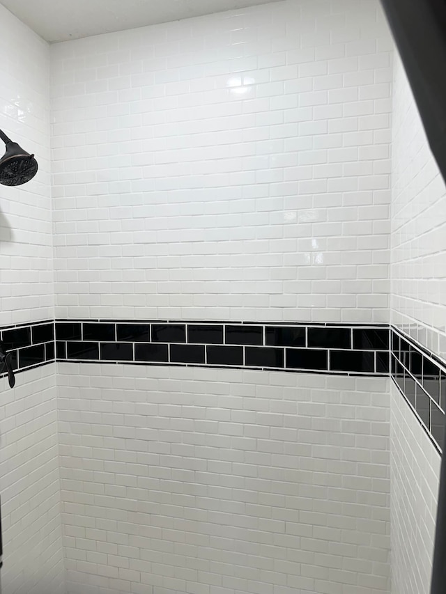 interior details featuring a tile shower