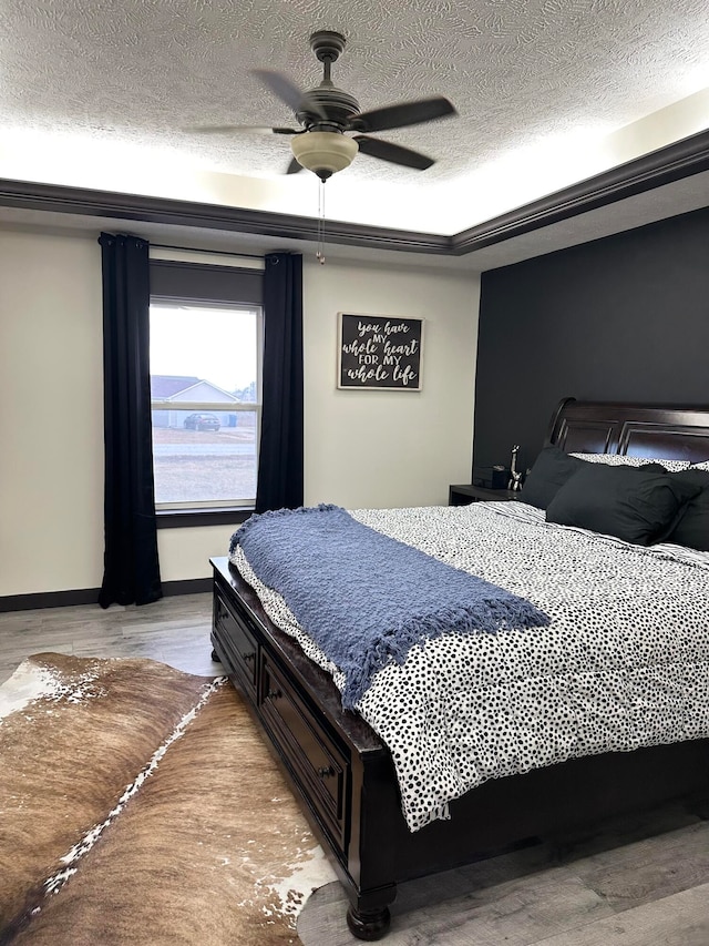 bedroom featuring a textured ceiling, light hardwood / wood-style floors, and ceiling fan