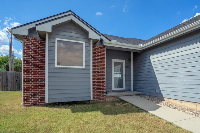 view of exterior entry with a yard