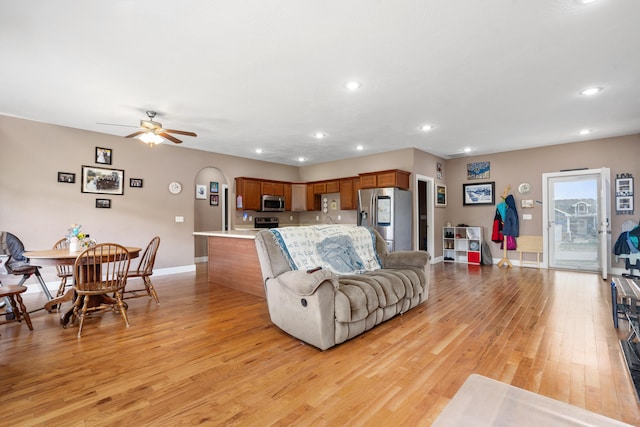 living room featuring light hardwood / wood-style floors and ceiling fan