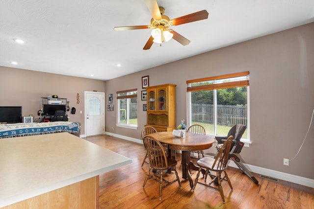 dining area with light wood-type flooring and ceiling fan