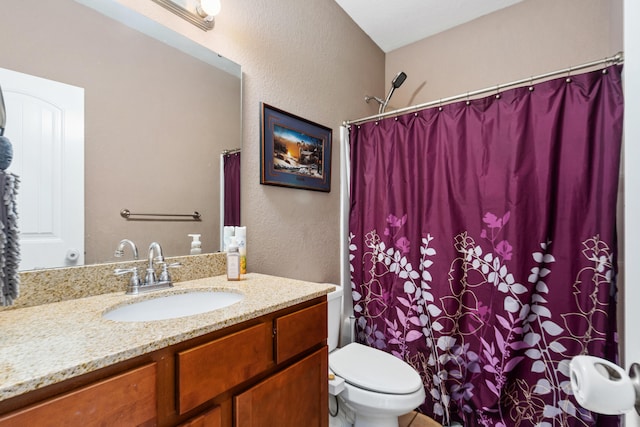 bathroom featuring vanity, toilet, and walk in shower