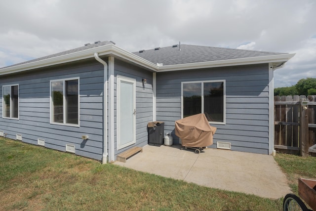 back of property featuring a patio and a lawn