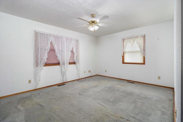 carpeted empty room featuring ceiling fan and a textured ceiling