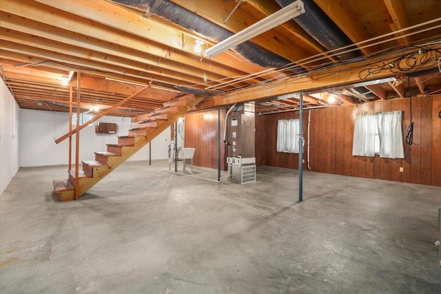 basement featuring heating unit and wood walls