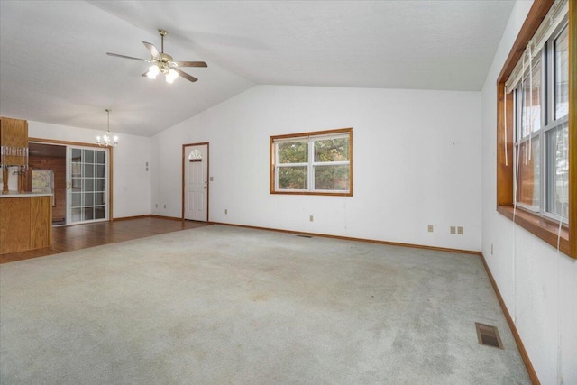 unfurnished living room with carpet, vaulted ceiling, and ceiling fan with notable chandelier