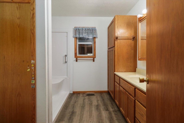 bathroom with vanity, a textured ceiling, and wood-type flooring