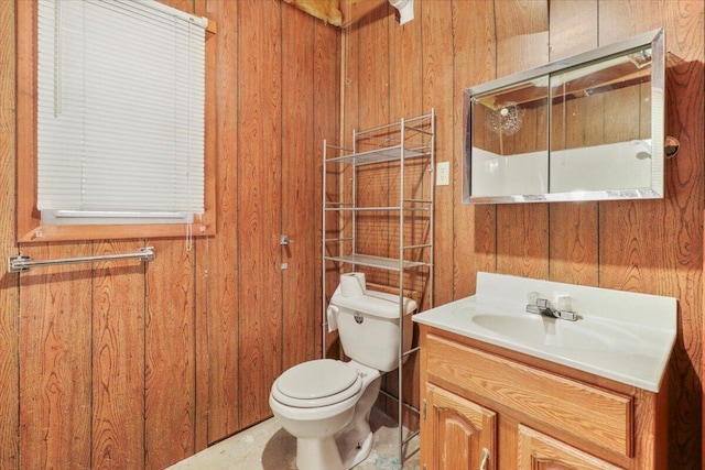 bathroom with vanity, a shower, toilet, and wood walls