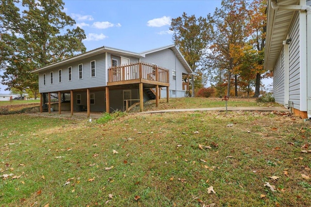 rear view of property featuring a wooden deck and a lawn