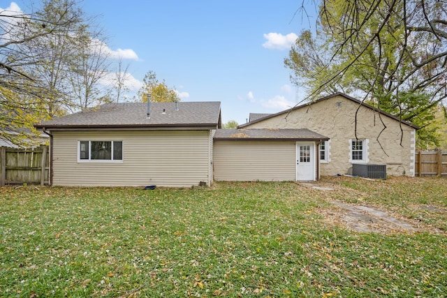 back of property with a yard and central AC unit