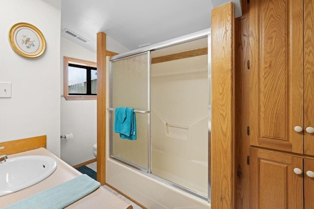 bathroom with visible vents, vanity, toilet, lofted ceiling, and enclosed tub / shower combo