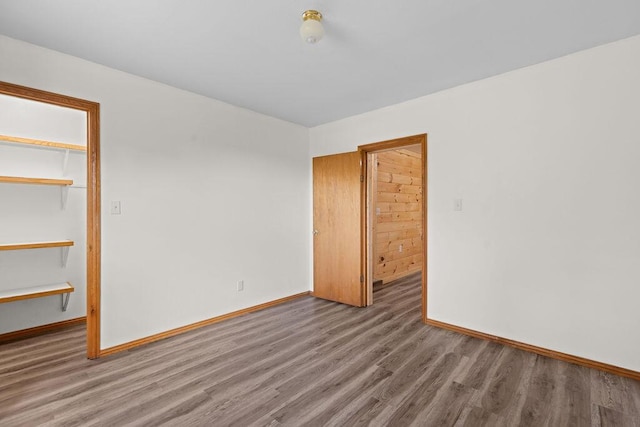unfurnished bedroom with baseboards, a closet, and wood finished floors