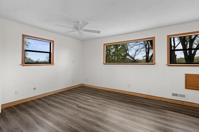 unfurnished room featuring visible vents, plenty of natural light, and wood finished floors