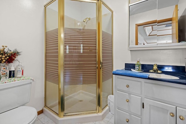 bathroom featuring vanity, toilet, tile patterned flooring, and a stall shower