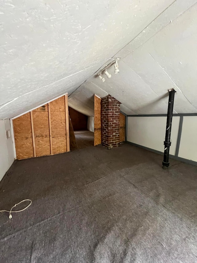 additional living space featuring a textured ceiling and vaulted ceiling