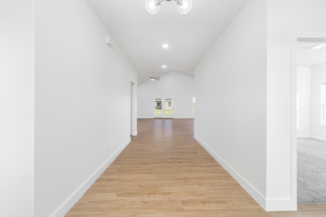 corridor featuring lofted ceiling and light wood-type flooring