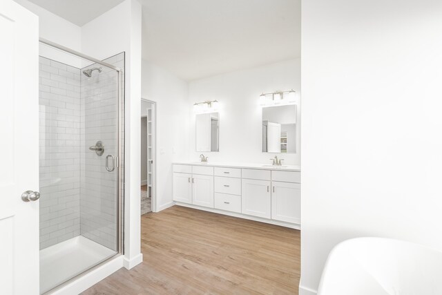 bathroom featuring vanity, independent shower and bath, and hardwood / wood-style floors