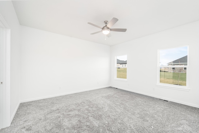 carpeted spare room with ceiling fan