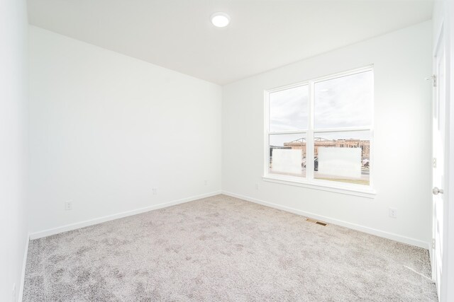 spare room featuring light colored carpet