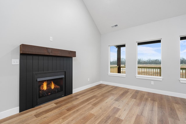 unfurnished living room with high vaulted ceiling and light hardwood / wood-style flooring