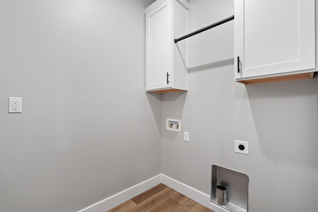 washroom with cabinets, washer hookup, light hardwood / wood-style flooring, and electric dryer hookup