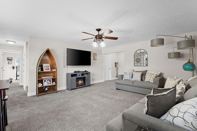 carpeted living room featuring a textured ceiling, a fireplace, and ceiling fan