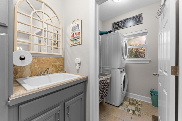 laundry area with sink, stacked washer and dryer, and light tile patterned floors