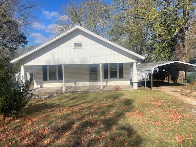 back of house with a porch, a yard, and a carport