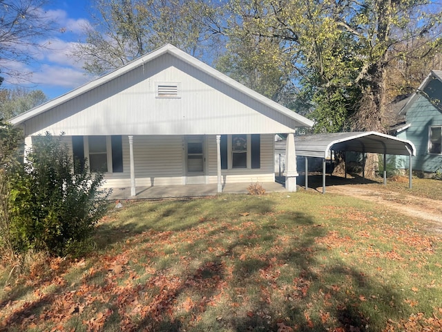 exterior space featuring covered porch, a lawn, and a carport