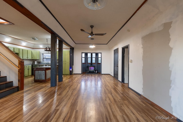 unfurnished living room featuring ceiling fan, sink, and dark hardwood / wood-style floors