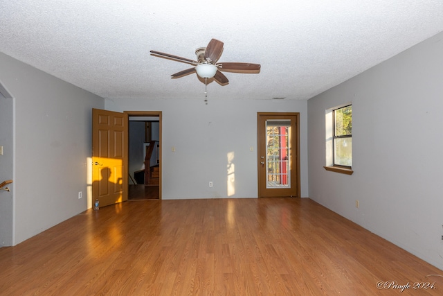 unfurnished room featuring ceiling fan, hardwood / wood-style flooring, and a textured ceiling