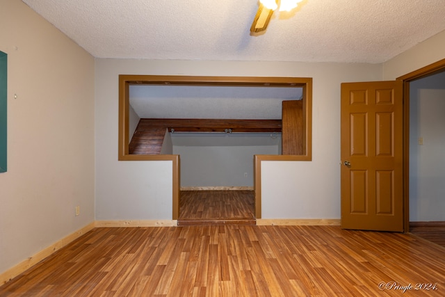 spare room with a textured ceiling and hardwood / wood-style flooring