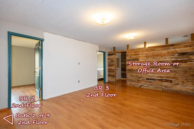 unfurnished room featuring light hardwood / wood-style floors and a textured ceiling