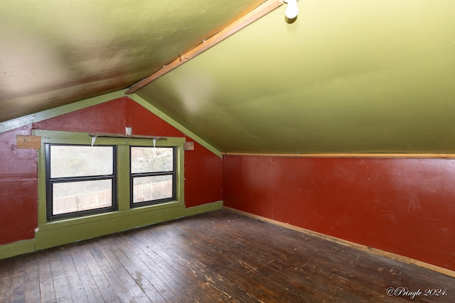 additional living space with dark hardwood / wood-style flooring and vaulted ceiling