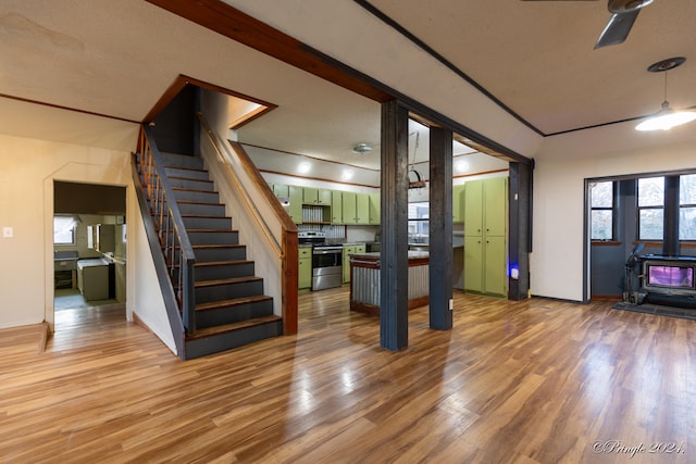 unfurnished living room with a wood stove and wood-type flooring