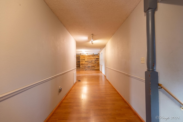 hall featuring a textured ceiling and light wood-type flooring