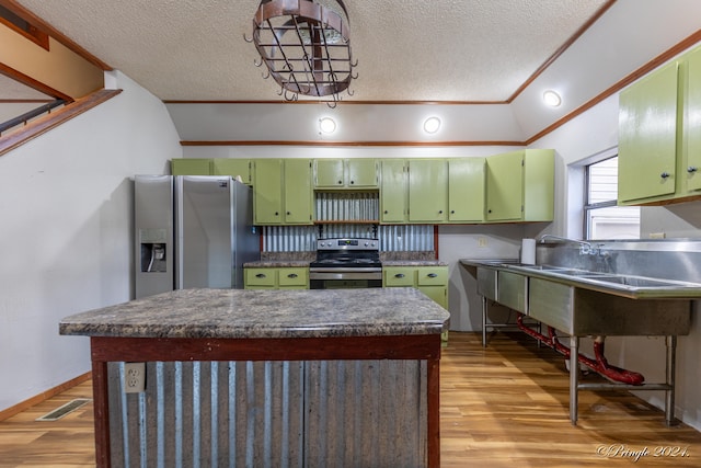 kitchen with light wood-type flooring, a textured ceiling, stainless steel appliances, lofted ceiling, and ornamental molding