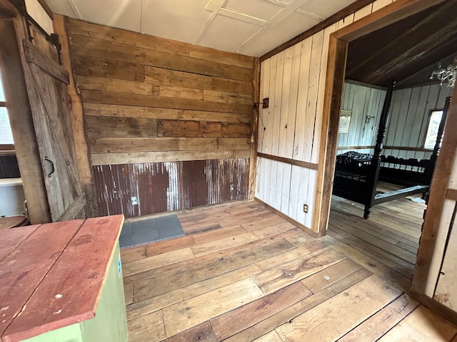 spare room featuring light wood-type flooring and wooden walls