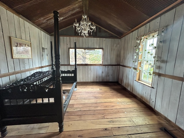 interior space featuring wood ceiling, light hardwood / wood-style flooring, vaulted ceiling, a notable chandelier, and wood walls