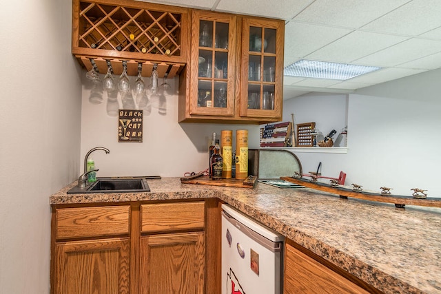 interior space with sink, a drop ceiling, and stainless steel fridge