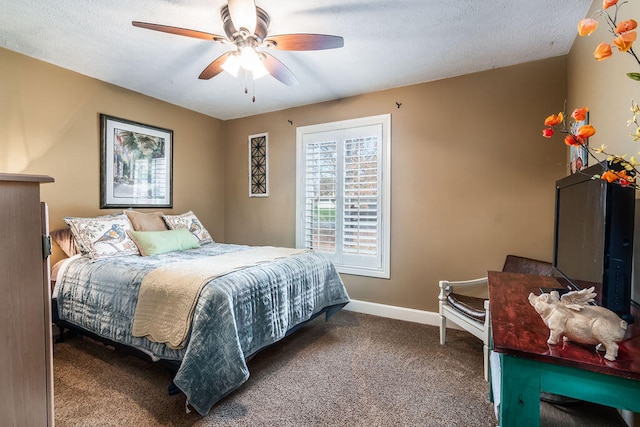 bedroom featuring dark colored carpet, a textured ceiling, and ceiling fan