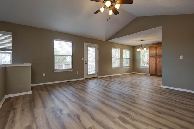 81 Clear Cove Dr, Reeds Spring, MO 65737 - unfurnished living room with a chandelier, a ceiling fan, plenty of natural light, lofted ceiling, and wood finished floors