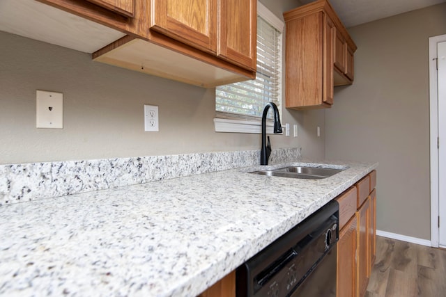 81 Clear Cove Dr, Reeds Spring, MO 65737 - kitchen with black dishwasher, a sink, dark wood-style floors, brown cabinets, and light stone countertops