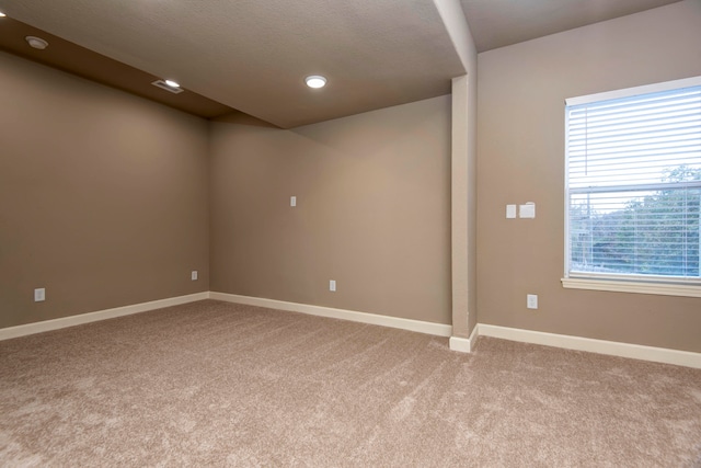 carpeted spare room with a textured ceiling