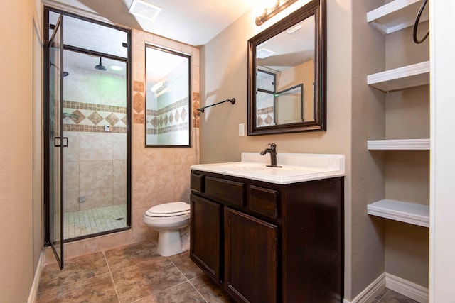 bathroom with a shower with door, toilet, and vanity