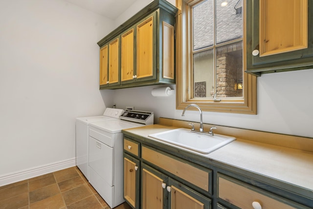 laundry room featuring cabinets, sink, separate washer and dryer, and dark tile patterned flooring